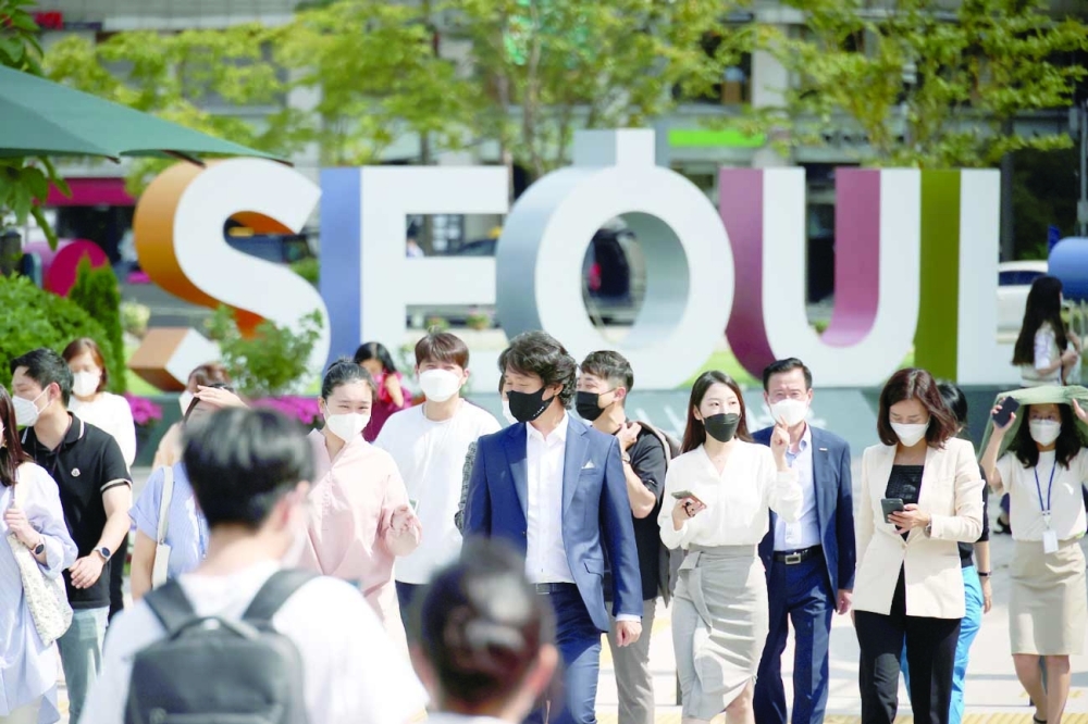 Commuters wearing masks walk on a zebra crossing in Seoul. -- Reuters