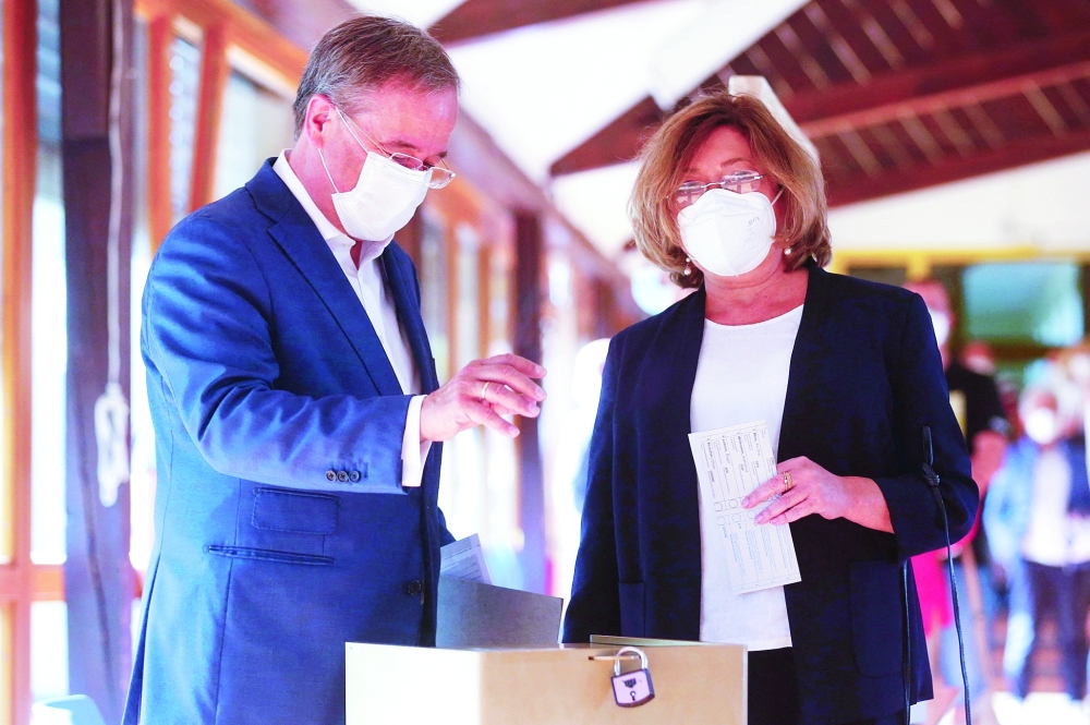 Germany's conservative CDU leader and candidate for chancellor Armin Laschet and his wife Susanne after casting his vote at a polling station in Aachen. - AFP