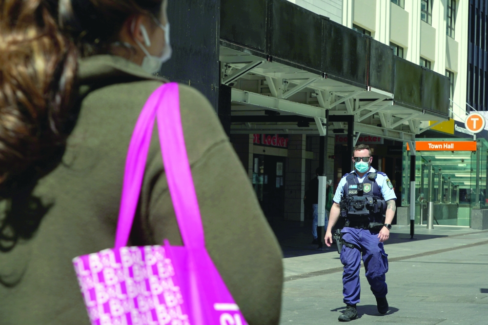 A police officer wearing a protective face mask patrol in the city centre during a lockdown to curb the spread of Covid-19 outbreak in Sydney. - Reutesrs,
