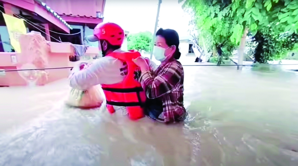 A rescuer uses a rope to carry a victim across flood waters in the Chaiyaphum province, Thailand, on Wednesday. — Reuters