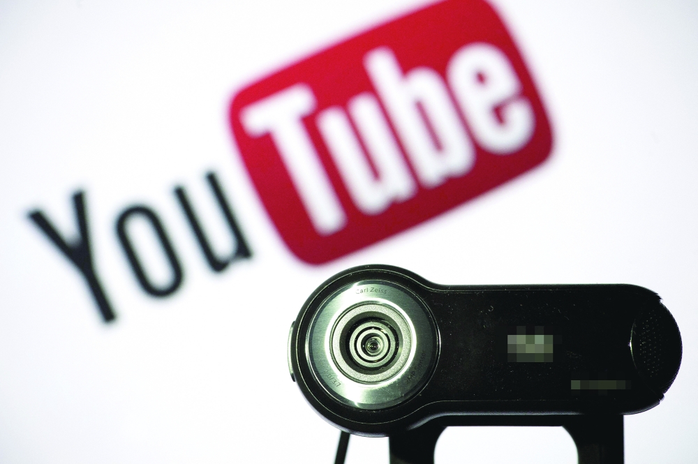 A webcam is positioned in front of YouTube’s logo in Paris. — AFP File