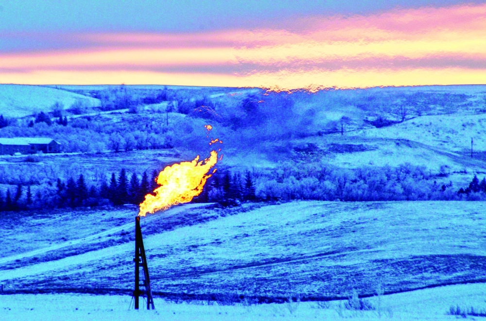 FILE PHOTO: FILE PHOTO: A natural gas flare on an oil well pad burns as the sun sets outside Watford City, North Dakota