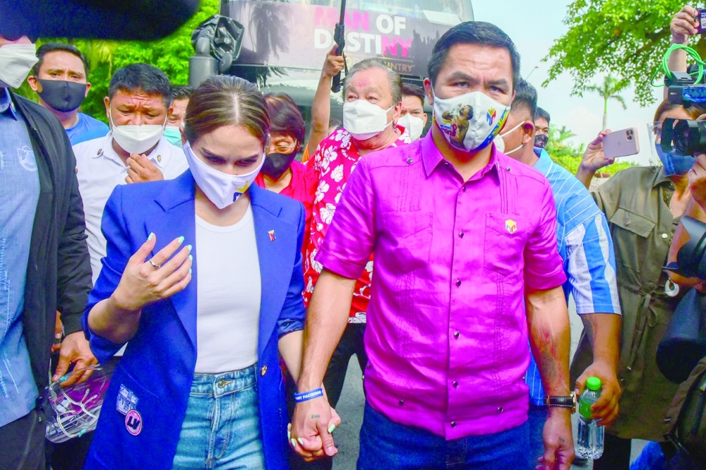 Philippine boxing icon and senator Manny Pacquiao, accompanied by his wife Jinkee, arrives to file his certifcate of candidacy for the Philippine presidency in Manila on Friday. -- AFP
