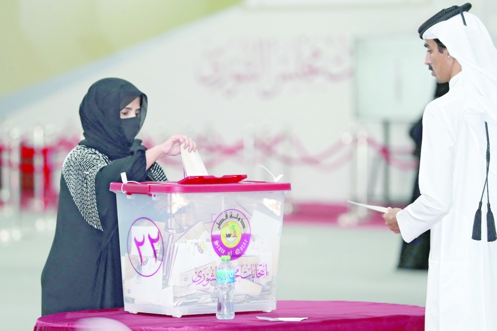 A Qatari woman casts her ballot at a polling station in the northern coastal city of Fuwayrit. -- AFP
