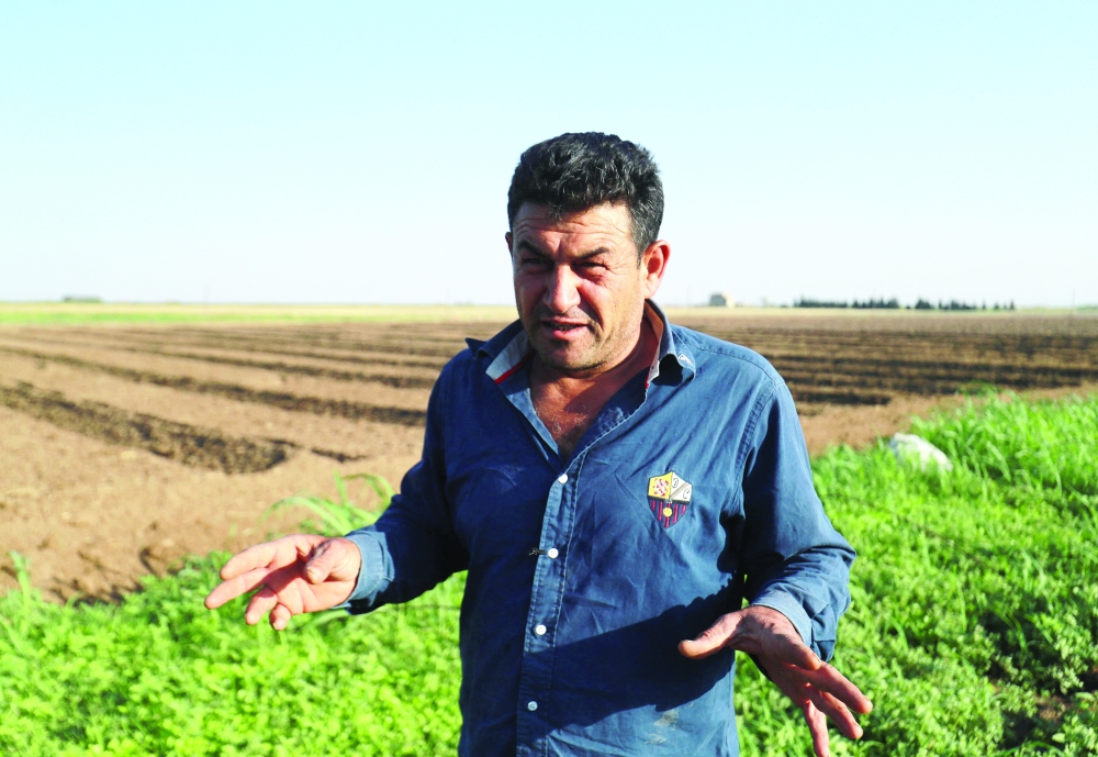 Syrian farmer Abdelbaqi Souleiman speaks during an interview as he checks on his agricultural land in the countryside of the northeastern city of Qamishli. - AFP