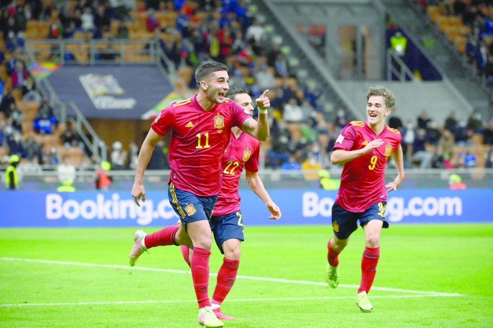 Spain's forward Ferran Torres (L) celebrates with teammates after scoring a goal during the UEFA Nations League semifinal football match between Italy and Spain at the San Siro (Giuseppe-Meazza) stadium in Milan, on October 6, 2021. (Photo by FRANCK FIFE / AFP)


