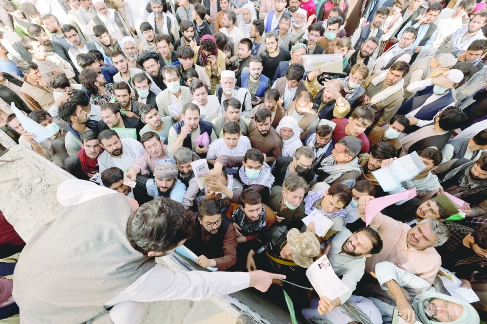 Afghans gather outside the passport office in Kabul after Taliban officials announced they will start issuing passports to its citizens again. -- Reuters
