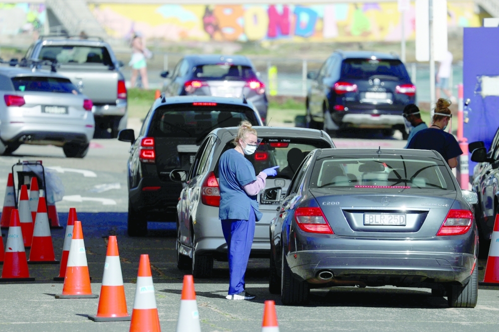 A health worker speaks with a person inside a vehicle at the Bondi Beach drive-through coronavirus disease testing centre in Sydney. -- Reuters