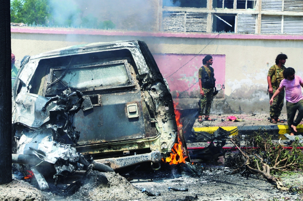Policemen stand at the scene of a blast in Aden, Yemen, on Sunday. - Reuters