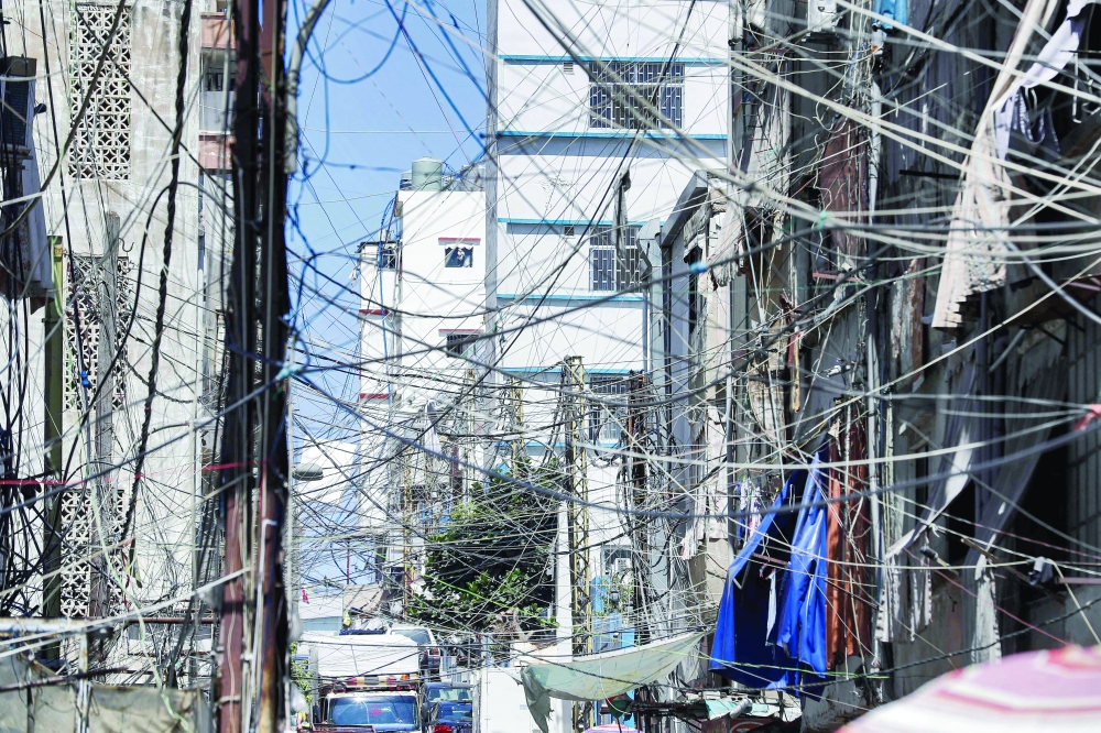 A file photo shows a view of a mesh of raised electricity lines along a street in a suburb of Lebanon's capital Beirut. - AFP
