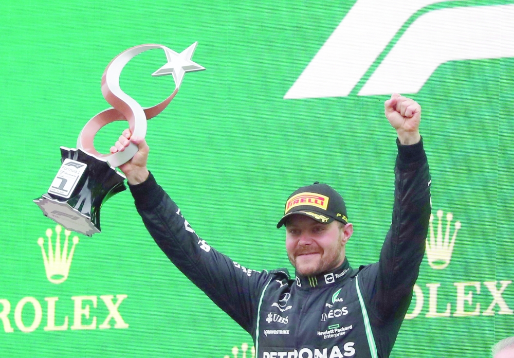 Mercedes' Valtteri Bottas celebrates with the trophy on the podium after winning the race. -- Reuters