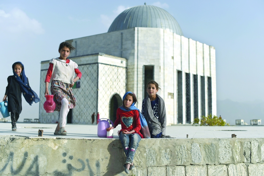 Afghan girls selling tea and water wait for customers at Nadir Khan hilltop in Kabul. - AFP