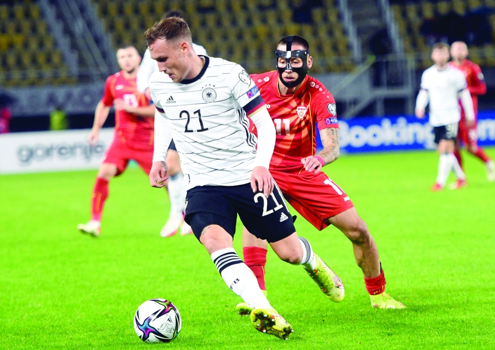Macedonia's Darko Churlinov (R) and Germany's David Raum fight for the ball during the FIFA World Cup Qatar 2022 qualification match. -- AFP
