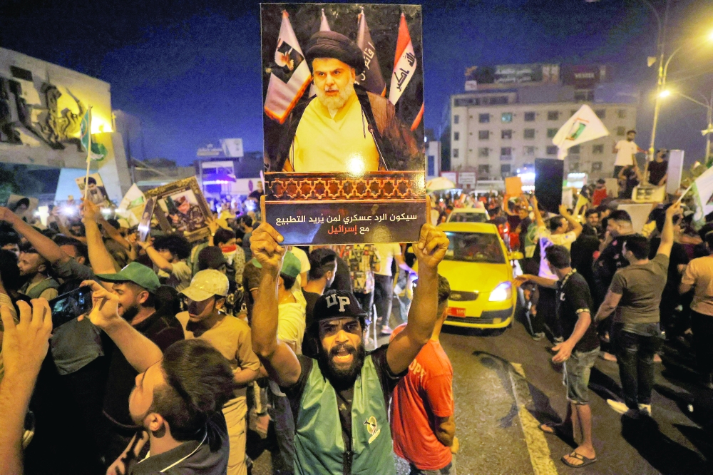Supporters of Moqtada al Sadr celebrate in Baghdad's Tahrir square on Monday night. - AFP