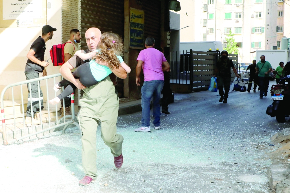 A man carrying a girl runs after gunfire erupted in Beirut on Thursday. --Reuters