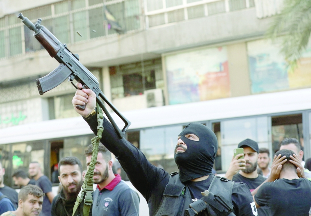 A member of Hezbollah fires his gun during the funeral of some of their members who were killed during clashes in the Tayouneh neighbourhood of Beirut on Friday. -- AFP