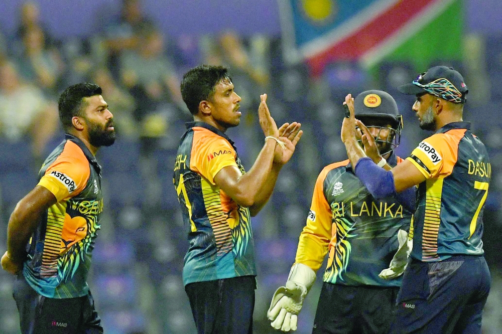 Sri Lanka's Maheesh Theekshana (C) celebrates with teammates after taking the wicket of Namibia's Jan Frylinck (not pictured) during the ICC men痴 Twenty20 World Cup cricket match between Namibia and Sri Lanka at the Sheikh Zayed Stadium in Abu Dhabi on October 18, 2021. (Photo by INDRANIL MUKHERJEE / AFP)

