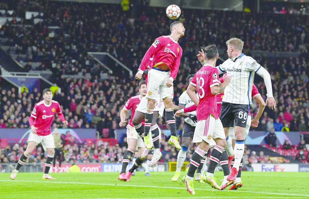 TOPSHOT - Manchester United's Portuguese striker Cristiano Ronaldo jumps to header the ball during the UEFA Champions league group F football match between Manchester United and Atalanta at Old Trafford stadium in Manchester, north west England, on October 20, 2021. Manchester United won the match 3-2. (Photo by Paul ELLIS / AFP)

