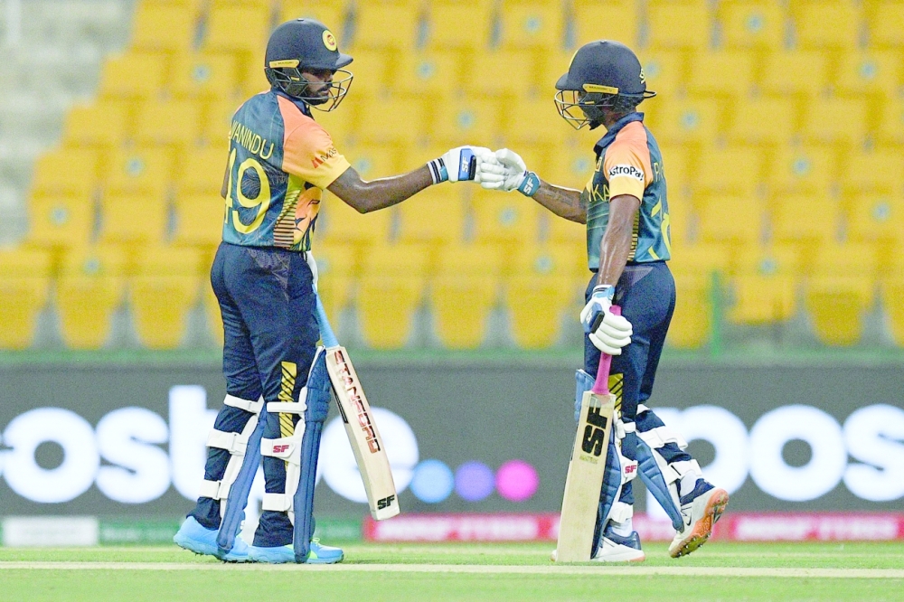 Sri Lanka's Wanindu Hasaranga de Silva (L) and Sri Lanka's Pathum Nissanka fist bump after Hasaranga's boundary shot during the ICC men痴 Twenty20 World Cup cricket match between Sri Lanka and Ireland at the Sheikh Zayed Stadium in Abu Dhabi on October 20, 2021. (Photo by INDRANIL MUKHERJEE / AFP)

