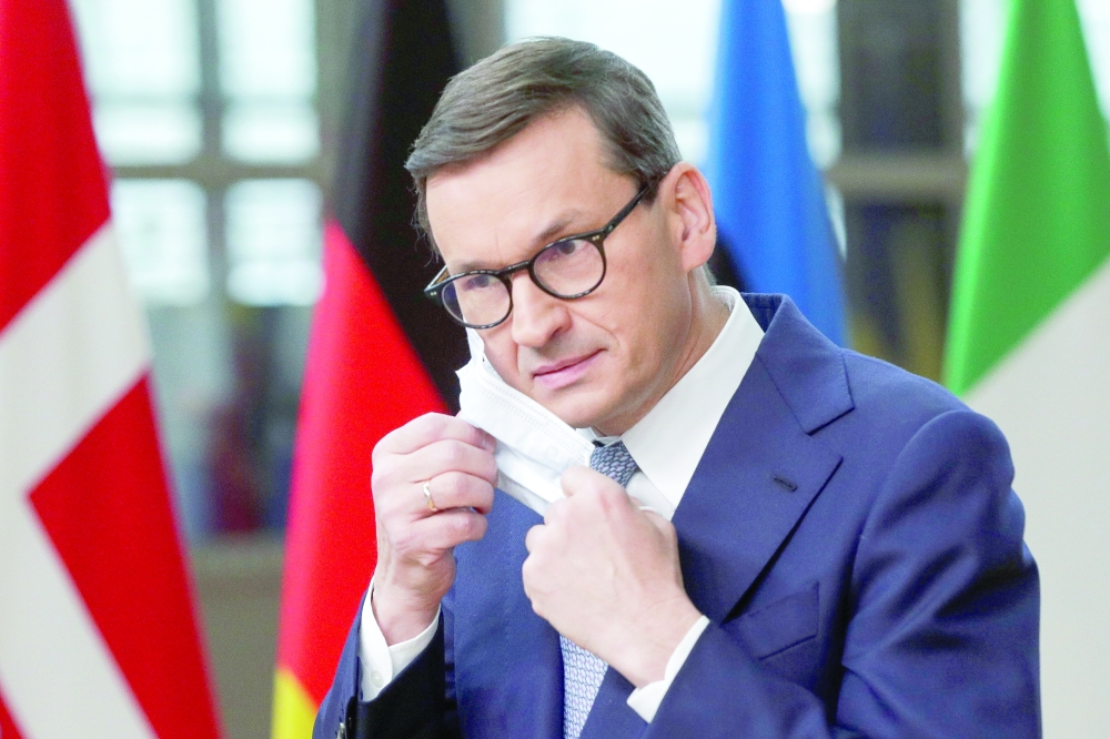 Poland's Prime Minister Mateusz Morawiecki adjusts his mask as he attends an EU leaders summit in Brussels, on Thursday. - Reuters