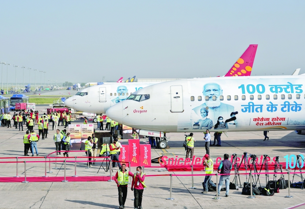 Ground staff and media gather during the unveiling of SpiceJet's special livery on its Boeing 737 aircraft to celebrate the milestone of administering one billion Covid vaccine doses in India, at the Indira Gandhi International Airport in New Delhi, on Thursday. - Reuters