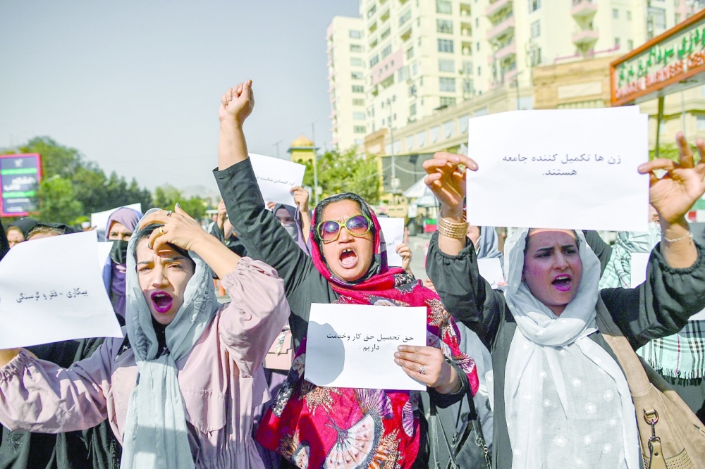 Afghan women chant slogans and hold placard during a women's rights protest in Kabul on Thursday. - AFP