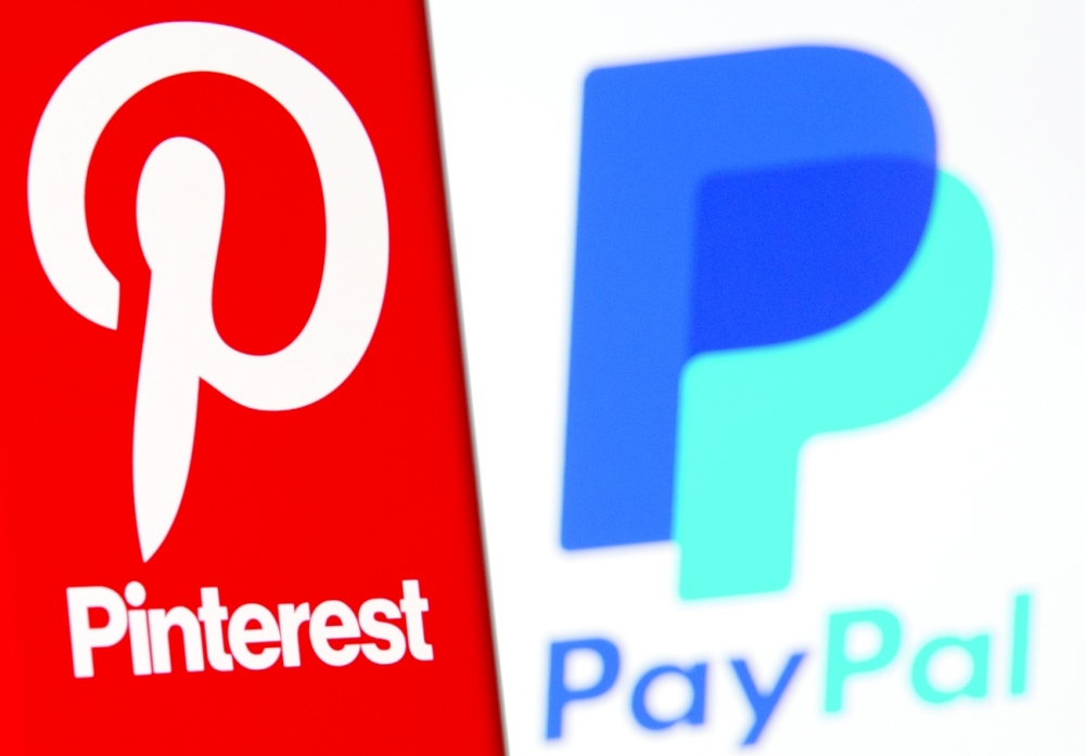 A Pinterest logo is seen on a smartphone in front of a displayed PayPal logo in this illustration. - Reuters