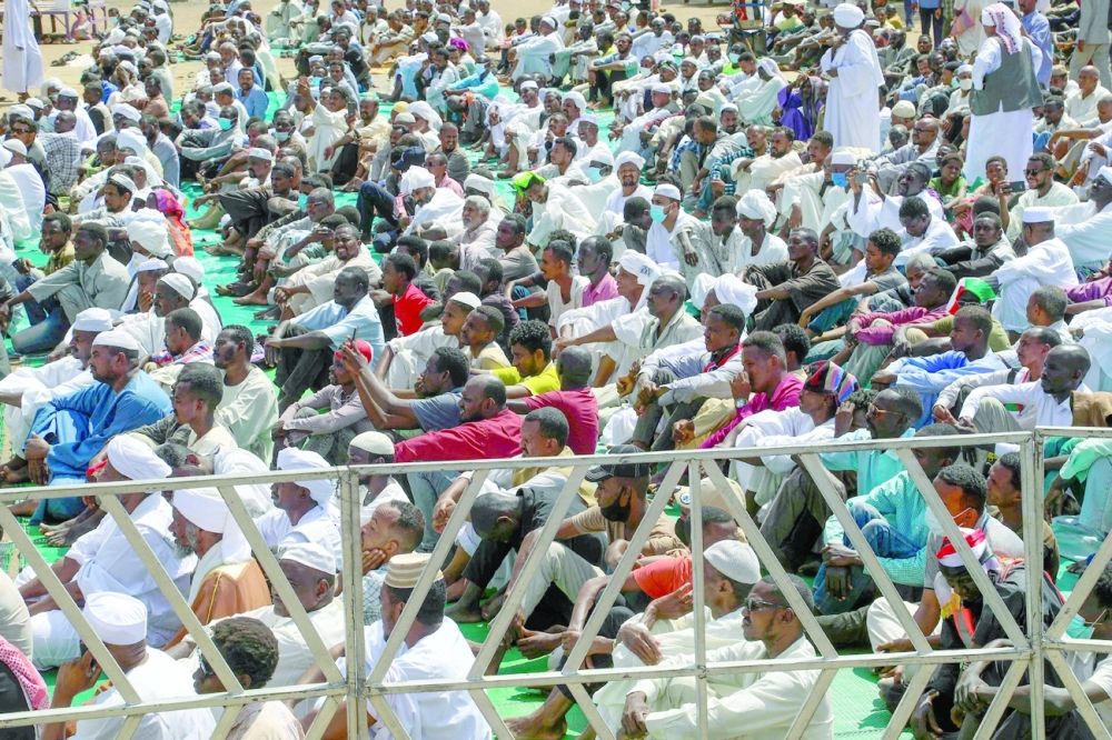Pro-military protesters perform Friday prayers with the participation of the Minister of Finance in front of the presidential palace in Khartoum on Friday. - AFP