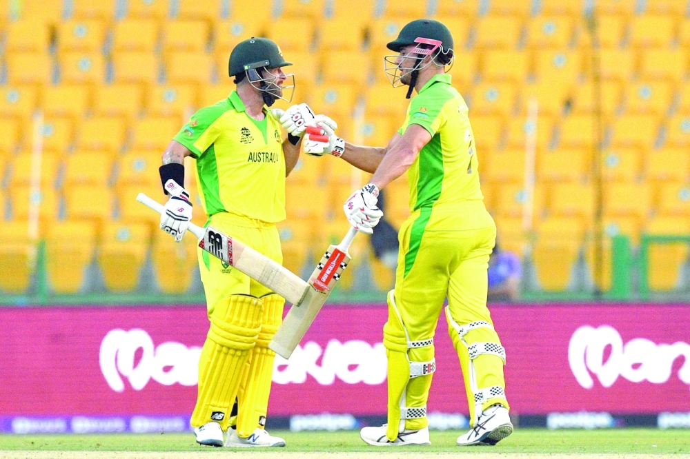 Australia's Marcus Stoinis (R) and teammate Matthew Wade bump their fists after beating South Africa in the ICC T20 World Cup Group I match at the Sheikh Zayed Cricket Stadium in Abu Dhabi. -- AFP