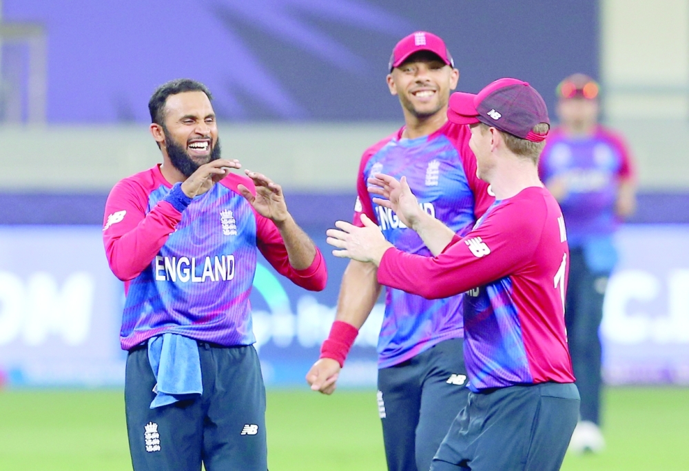 England's Adil Rashid celebrates with team-mates after taking the wicket to dismiss West Indies' Obed McCoy. -- Reuters