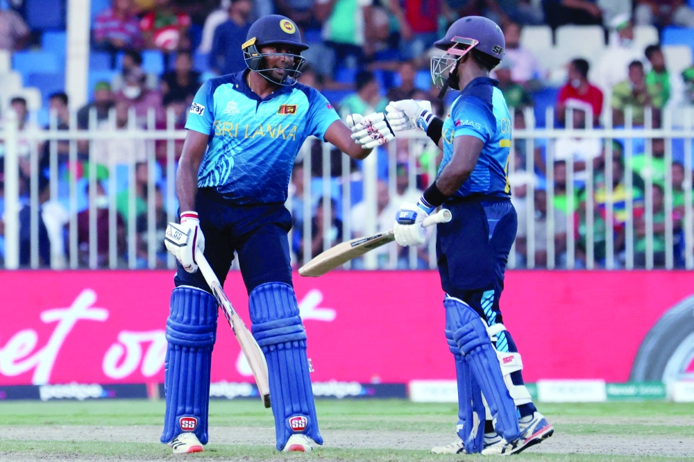 Sri Lanka's Bhanuka Rajapaksa (L) and his teammate Charith Asalanka bump their fists during the ICC T20 World Cup match against Bangladesh at the Sharjah Cricket Stadium in Sharjah. -- AFP