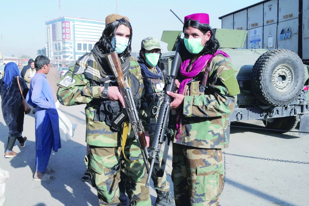 A Taliban fighter and his comrade pose for a photograph at the market in Kabul, Afghanistan, on Sunday. - Reuters