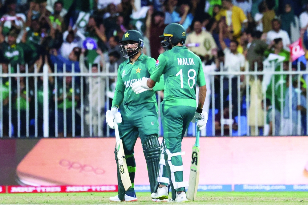 Pakistan's Asif Ali and Shoaib Malik (R) talk during the ICC T20 World Cup match against New Zealand at the Sharjah Cricket Stadium. -- AFP