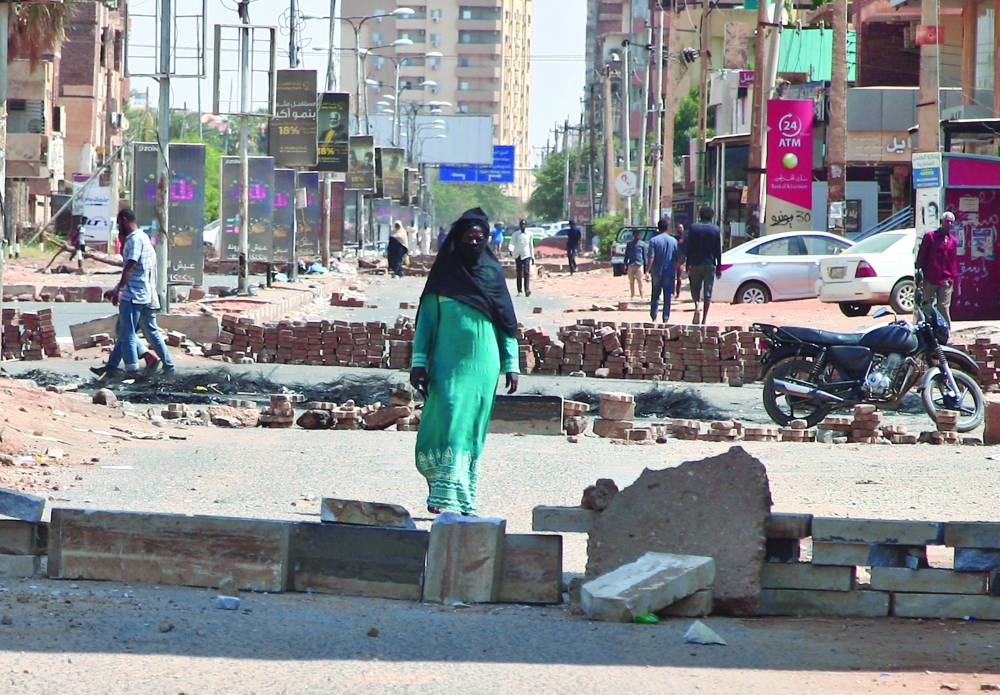 Anti-coup protesters use bricks to barricade a street in Khartoum on Wednesday. - AFP