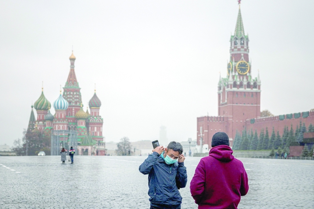 A man puts his face mask as he stands in a deserted Red Square amid the outbreak of Covid-19 in Moscow on Thursday. - AFP 