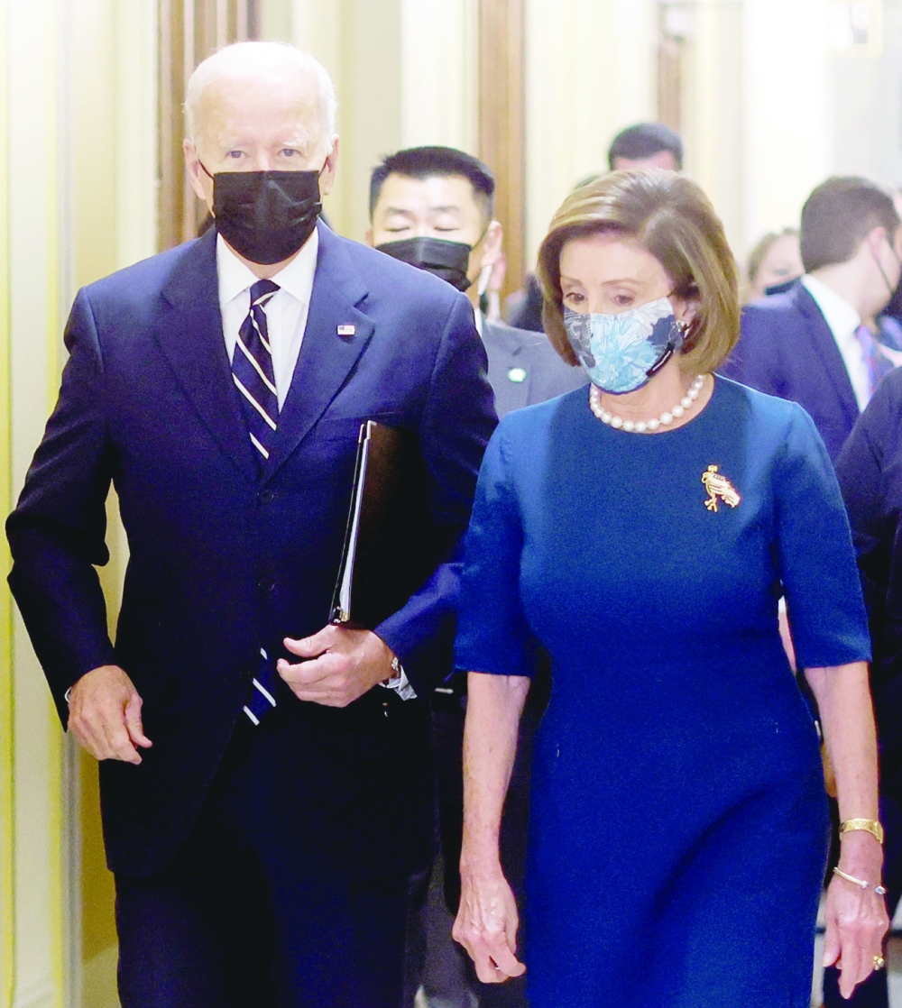 President Joe Biden is escorted by House Speaker Nancy Pelosi as he arrives to speak to the House Democratic Caucus at the US Capitol on Thursday. - Reuters