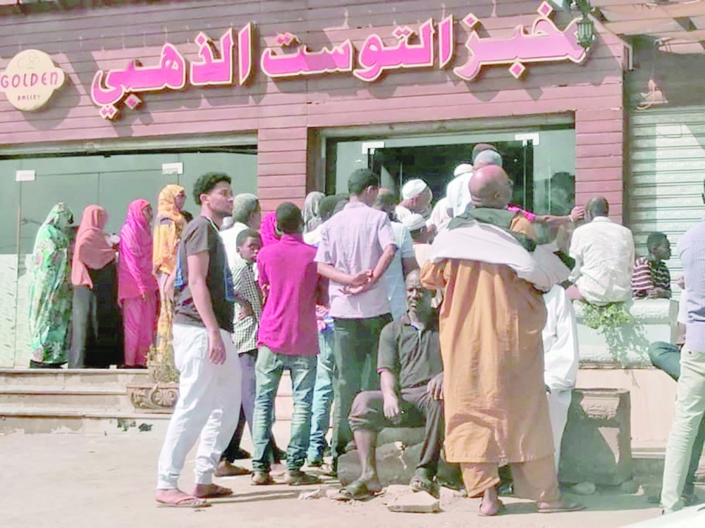Sudanese queue for bread outside a bakery in the capital Khartoum on Thursday. - AFP 