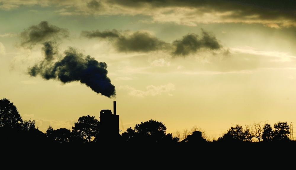FILE PHOTO: Smoke rises above a factory at sunset in Rugby