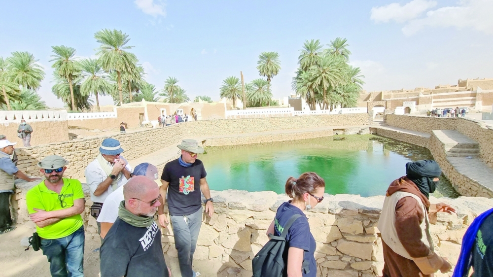 European tourists, escorted by security personnel, walk past the spring water pool in the old town of Ghadames, a desert oasis some 650km southwest of the Libyan capital Tripoli. - AFP 