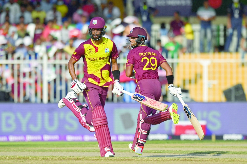 West Indies' Nicholas Pooran (R) and team-mate Roston Chase run between the wickets during the ICC T20 World Cup match against Bangladesh. -- AFP