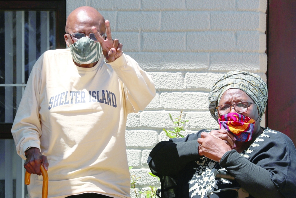 Archbishop Desmond Tutu, with his wife Leah, waves after they cast special ballots ahead of the November 1 local government elections in Cape Town. - Reuters