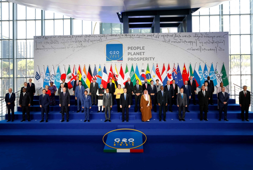 Italian Prime Minister Mario Draghi (front) stands with world leaders as they gather for the official family photograph on day one of the G20 Summit at the convention center of La Nuvola, Rome. - AFP