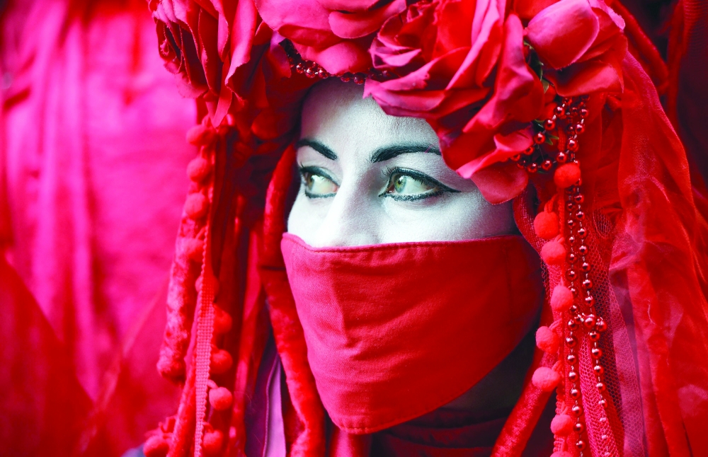 A member of the Red Rebel Brigade - an international performance artivist troupe - join climate activists from the Extinction Rebellion group as they demonstrate in Glasgow, during the COP26 UN Climate Change Conference, on Tuesday. - AFP