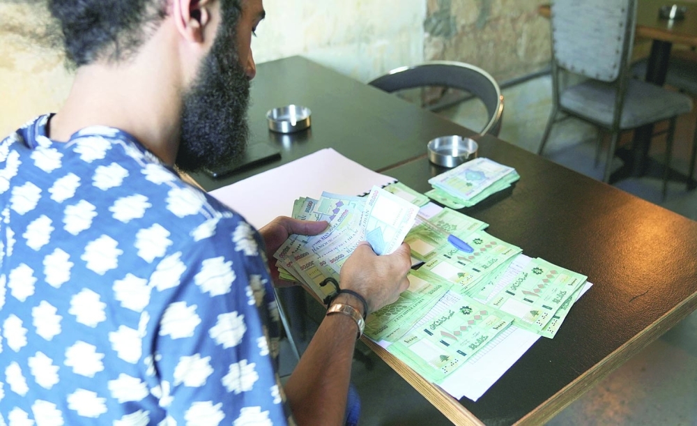 Moussa Yaakoub, a Lebanese hotel owner, counts Lebanese pound banknotes in Beirut, Lebanon. - Reuters