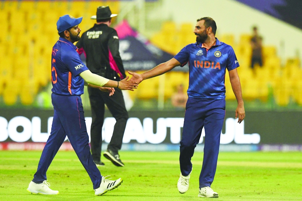 India's Rohit Sharma (L) congratulates his teammate Mohammed Shami after he took the wicket of Afghanistan's captain Mohammad Nabi (not pictured). -- AFP  