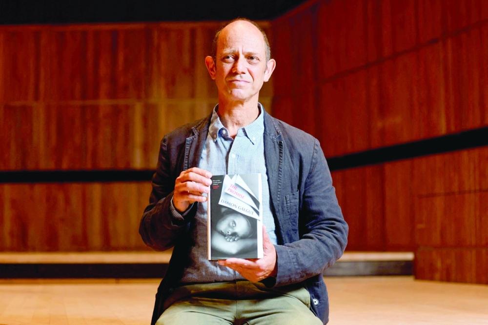(FILES) In this file photo taken on October 31, 2021 South African author Damon Galgut poses with his book 'The Promise' during the photo call for authors shortlisted for the 2021 Booker Prize for Fiction at Southbank Centre in London. South African playwright and novelist Damon Galgut on November 3, 2021, won the 2021 Booker Prize for "The Promise", his third shortlisted novel which chronicles a family in his homeland from the late apartheid era through to Jacob Zuma's presidency. (Photo by Tolga Akmen / AFP)
