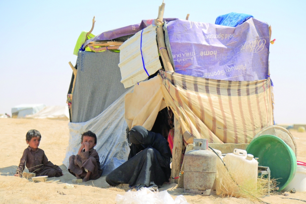 A woman sits with children at a camp for internally displaced people on the outskirts of Yemen's northeastern city of Marib. - AFP