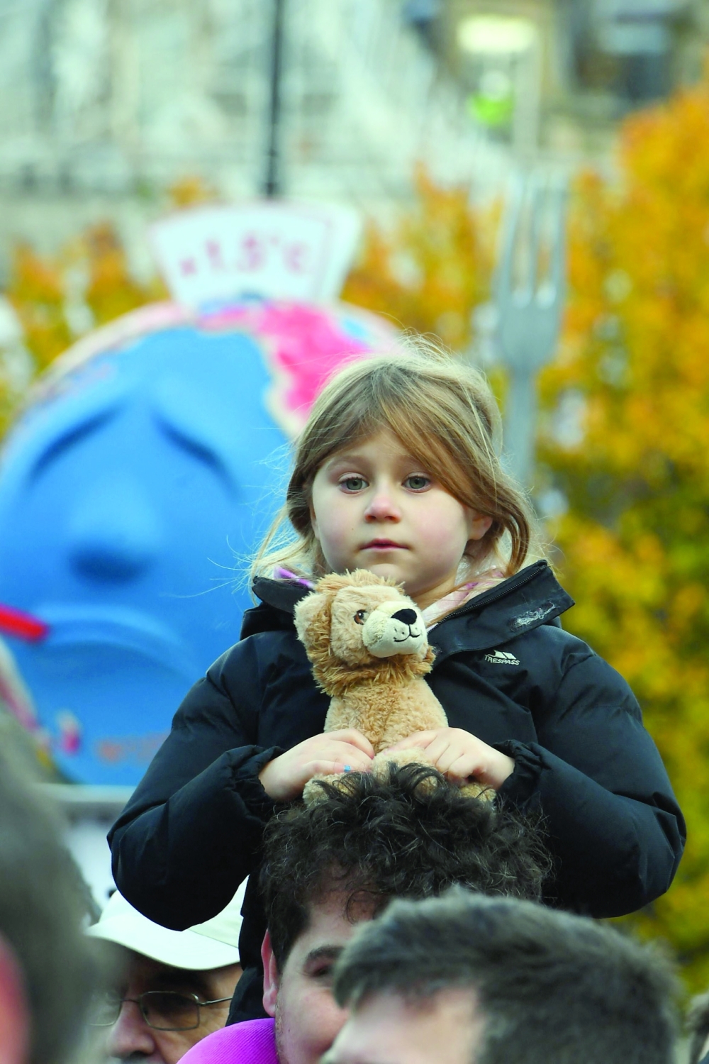 A young girl holds a toy lion as protesters wait for speeches to start in George Square in Glasgow. - AFP 