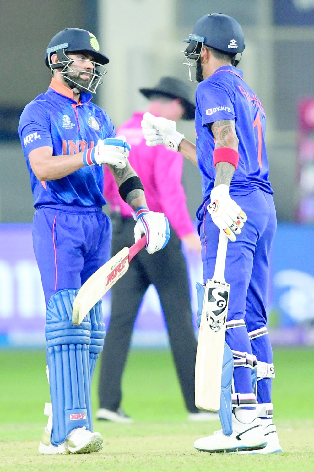India's KL Rahul (R) bumps fists with captain Virat Kohli. -- AFP