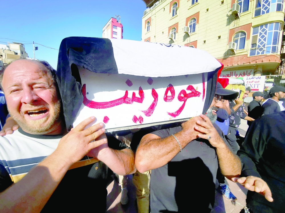 Mourners carry coffins of supporters of armed groups who were killed in clashes with Iraqi security forces on Friday night, during a funeral in Najaf, on Saturday. - Reuters
